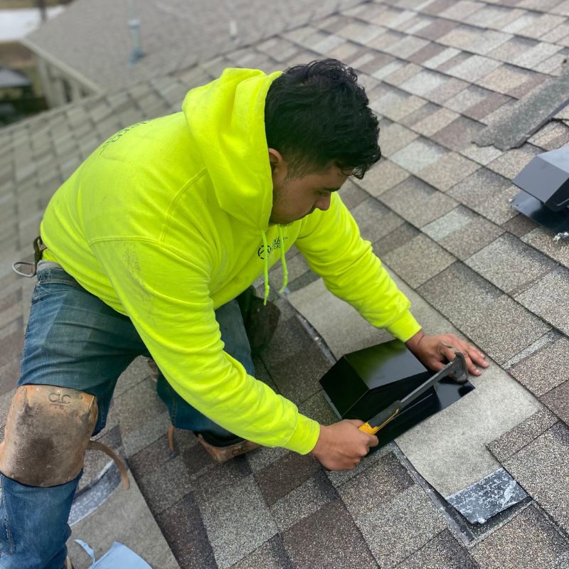 Modern Exterior roofer is Replacing a roof bath vent on a shingle roof with ice and water around the vent.
