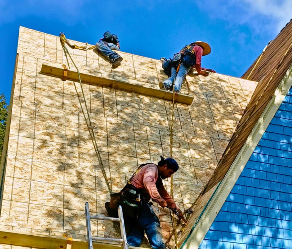 Men roofing on steep roof with OSB decking